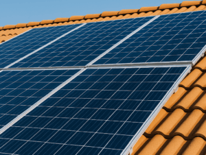 Solar panels installed on a house roof under bright blue skies, highlighting renewable energy and eco-friendly power solutions.